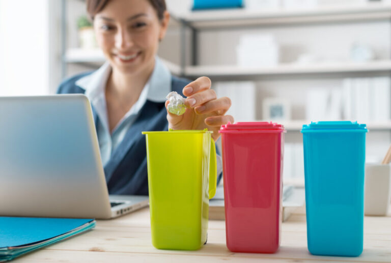 Waste separate collection and recycling in the workplace, office worker sorting garbage using different trash bins